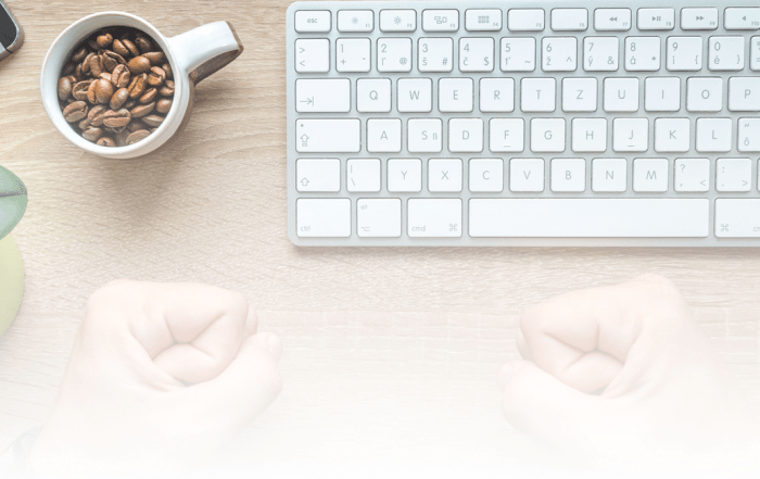 A keyboard and coffee cup on a table 